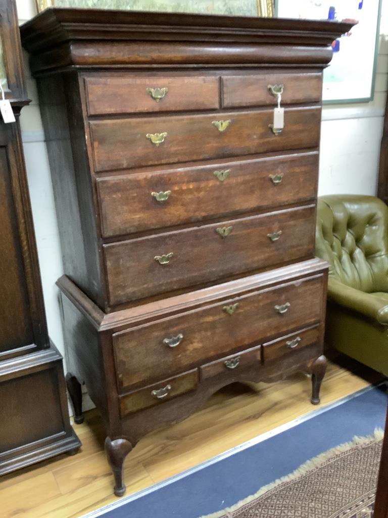 An 18th century cross banded oak chest on stand, width 116cm, depth 57cm, height 170cm